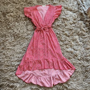 Röd blommig klänning med volang - Röd klänning med små vita blommor och volangdetaljer. Använd väldigt få gånger. 