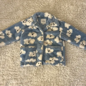 Blå teddyjacka med molnmönster från Monki - En supermjuk och gosig blå teddyjacka med molnmönster från Monki 