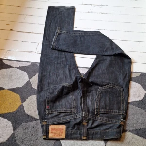 Svarta jeans från Replay - Snygga svarta jeans från Replay med klassisk femficksdesign och en liten logga på bakfickan. De har en rak passform och är tillverkade i slitstarkt denim. Perfekta för en stilren look.