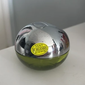 DKNY Be Delicious parfym - Säljer en oanvänd fräsch och fruktig parfym från DKNY, Be Delicious. Flaskan har en unik äppelformad design med en silverfärgad topp och grön bas. Perfekt för dig som älskar en fräsch doft med inslag av äpple och blommor.