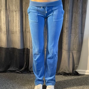 Blå velourbyxor från Juicy Couture - Snygga blå velourbyxor från Juicy Couture. Har använts en del men är fortfarande hela och fina! Modellen är 167cm lång