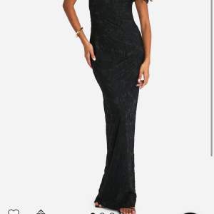 Elegant svart långklänning med ett subtilt blommigt mönster. Klänningen har en oneshoulder-design som ger en stilren look. Perfekt för speciella tillfällen. Ganska liten i storleken och tight i armarna. Har använts en gång🩵