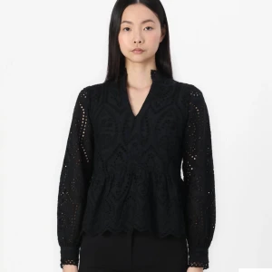 Svart blus med spetsdetaljer - Snygg svart blus med v-ringning och spetsdetaljer. Blusen har långa ärmar och en lätt volang vid nederkanten. Perfekt för en stilren look. Märket är Yas. Kostar 679kr ny❤️