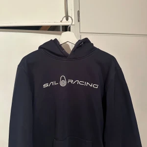 Marinblå hoodie från Sail Racing - Jag säljer min blåa Sail racing tröja som är i storlek XL inga skador med tröjan  PRISET KAN DISKUTERAS VID SNABB AFFÄR 