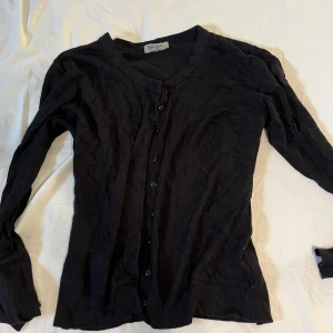 Svart cardigan med knappar - Säljer denna svarta cardigan med knappar. Tunt och skönt material. Storlek M men passar som en S