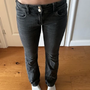 Svarta jeans med bootcut - Snygga svarta jeans med bootcut och låg midja. De har två knappar och dragkedja framtill samt fickor både fram och bak. Perfekta för att ha i vardagen