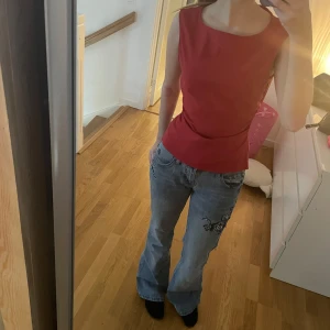 Röd ärmlös topp från vero Moda - Snygg röd ärmlös topp från vero Moda med en enkel och stilren design. Perfekt för att lägga till en färgklick i din garderob. Toppen har en dragkedja i ryggen för enkel på- och avtagning.