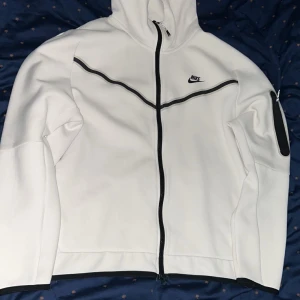 Vit Nike tech hoodie - Säljer min vita nike tech hoodie som är XL storlek men passar mer L och även M men passar jätte bra om man gillar lite baggy. Köptes från footlocker på mall of scandinavia. Säljer eftersom jag inte använder längre. Pris kan diskuteras!!. 