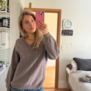 Grå tröja från Wera - Säljer en stilren och mjuk grå tröja från Wera. Tröjan har en v-ringad design och långa ärmar, perfekt för kyligare dagar. Passar utmärkt till både jeans och kjol. Perfekt för dig som älskar komfort och stil! 💫