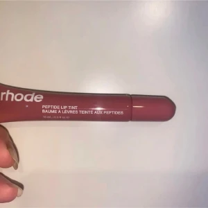 Hell ny och oanvänd Peptide Lip Tint från Rhode(priset kan diskuteras vid snabb affär) - Säljer en hell ny och oanvänd, lyxig läppbalsam med peptider som ger en subtil färg och vårdar läpparna. Perfekt för att hålla läpparna mjuka och återfuktade med en naturlig glans. Priset kan diskuteras vid snabb affär.