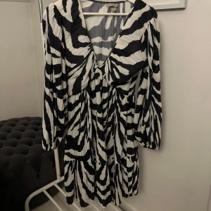 Zebramönstrad klänning  - Snygg zebramönstrad klänning med långa armar och urringning. 🦓 Plisserat material. Använd max 2 gånger så den är i väldigt fint skick. Skriv meddelande vid frågor/fler bilder 🩷