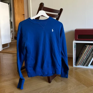 Blå tröja från Polo Ralph Lauren - Säljer en snygg blå tröja från Polo Ralph Lauren med det klassiska logotypbroderiet. Perfekt för en stilren och avslappnad look. Använd sparsamt 🌸