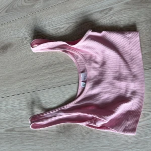 Rosa ribbad linnetopp från Divided - Säljer en söt rosa ribbad linnetopp från Divided. Perfekt för varma dagar eller som ett lager under en tröja. Toppen har en enkel och stilren design med breda axelband.🩷🩷