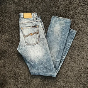 Nudie jeans  - Nudie jeans med helt galen wash och extremt bra passform. Modell Slacker Jack så alltså lite mer straigtfit. Storlek 31/36 men enligt mig sitter dom som 30/34. Litet hål bak höger ben som syns i bild 3 men inget som skadar, ser faktiskt ganska fett ut, om man inte gillar det kan man alltid få det reparerat hos nudie själva helt gratis. 