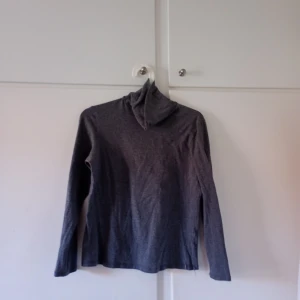 Grå polotröja från Isolde - Säljer en stilren grå polotröja från Isolde. Tröjan har långa ärmar och en klassisk polokrage, perfekt för kyligare dagar. Den är mjuk och bekväm, idealisk för lager-på-lager-stil.