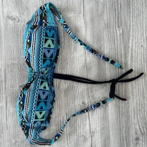 Mönstrad bikiniöverdel i blått XS - Snygg bikiniöverdel med ett färgglatt geometriskt mönster i blått, svart och turkos. Den har knytband i nacken och ryggen för justerbar passform. Passar XS-S 