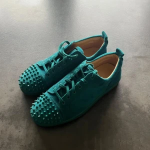 Christian loubouthin  - Snygga turkosa sneakers med nitar på tån och en röd sula. Skorna har snörning och är tillverkade i mocka, vilket ger dem en lyxig känsla. Perfekta för att sticka ut i mängden!