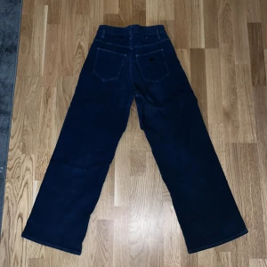 Mörkblå manchesterbyxor från Abrand Jeans - Snygga mörkblå manchesterbyxor från Abrand Jeans med en klassisk design. Byxorna har en rak passform och är perfekta för en stilren look. De har fickor både fram och bak samt en dragkedja i gylfen. Dom är korta i modellen.
