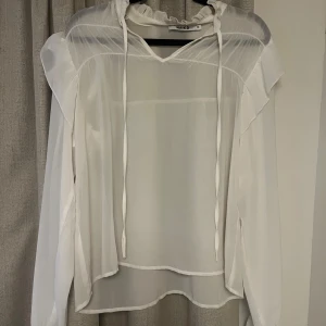 Vit genomskinlig blus med volang - Säljer nu min fina blus från Nakd! Som oanvänd.