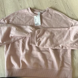 Rosa sweatshirt från Divided - Säljer en mjuk och stilren rosa sweatshirt från Divided. Tröjan har långa ärmar och en rund halsringning. Perfekt för en avslappnad look. Passar bra till jeans eller leggings. 🌸