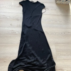 Svart klänning från Zara - Snygg svart klänning från Zara i storlek XS. Klänningen har en unik design med olika texturer och är ärmlös. Perfekt för en stilren look.🩷🩷