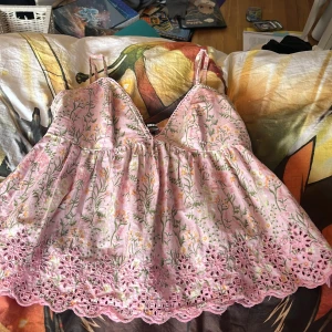 Blommig rosa topp från BikBok - Söt rosa topp från BikBok med blommigt mönster och spetsdetaljer. Den har smala band som går att anpassa, stretch i ryggen. Perfekt till sommaren :) nypris 400. Tryck gärna på köp nu 💗
