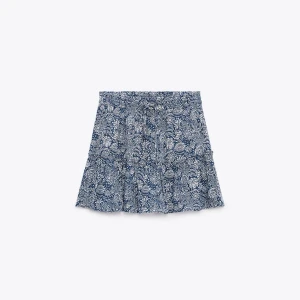 Blå blommig kortkjol - Kjol från zara med volang och inbyggda shorts. Aldrig använd. 