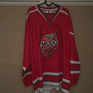 Röd MODO Hockeytröja från Easton - Säljer en röd Modo tröja med autografer från när Modo vara i SHL minns inte vilket årtal tröja är ifrån den är inte från säsongen 23/24 eller 24/25 den är från senare årtal 