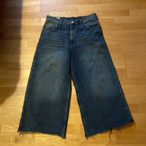 Mörkblåa baggy/wide jeans - Fina mörkblåa jeans som även är ljusare vid knäna/låren (ser de på första bilden). Dom är 43cm i midja och 92cm i längd, även klippta längst ner men inget som syns. Säljer dom för att jag inte använder dom längre.