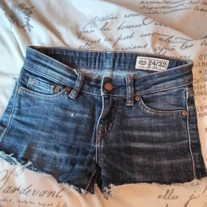 Low waist shorts - Säljer ett par snygga blå jeansshorts från Crocker. De är lågmidjade med fransiga kanter och klassisk femficksdesign. Perfekta för en avslappnad sommarlook! 🩵Storlek XS