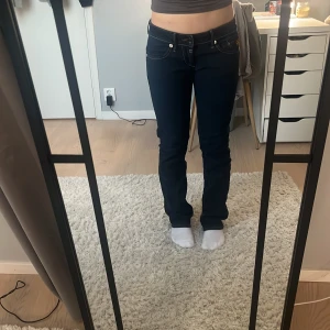 Mörkblå jeans från G-Star - Snygga mörkblå jeans från G-Star med normal passform och låg midja. Byxorna har klassisk femficksdesign och tydliga sömmar. Perfekta för en avslappnad stil.