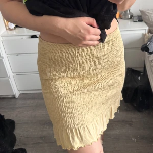 Gul ribbad kjol - Gul ribbad kjol med volangdetalj i nederkant. Kjolen har en tight passform. (Katt och kanin finns i hemmet) 