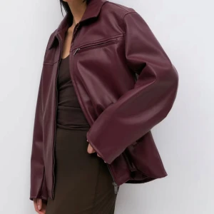 Vinröd skinnjacka XS - Snygg vinröd skinnjacka med dragkedja framtill och klassisk krage. Jackan har en stilren design med långa ärmar och en rak passform. Slutsåld på Gina Tricot.