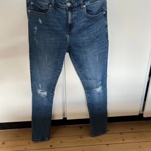 Blå jeans från Only & Sons - Snygga blå jeans från Only & Sons med en klassisk femficksdesign. De har en lätt slitning på framsidan för en trendig look. Perfekta för en avslappnad stil. W33 L32