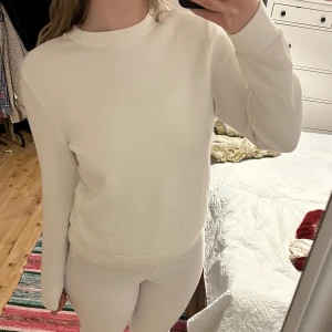 Vit sweatshirt - Säljer en stilren vit långärmad tröja med rund hals. Perfekt för en enkel och avslappnad look. Passar bra till både jeans och mjukisbyxor. Otroligt lent och mjukt material i viskos. 
