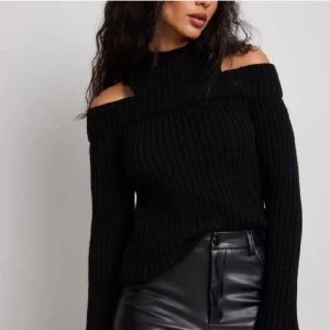 Svart stickad offshoulder tröja - Snygg svart stickad tröja med offshoulder-design. Perfekt för en stilren look med långa ärmar och en bekväm passform. Passar bra till både jeans och kjol. Nypris 549kr