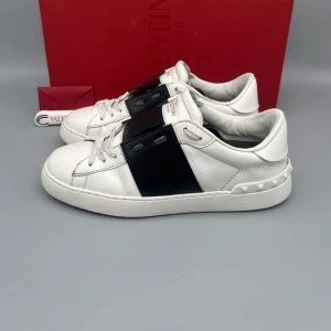 Valentino Garavani Open sneakers vit/svart ÄKTA! - • Skorna är sparsamt använda och i fint skick • Storlek: 39 (passar 39.5–40) • Färg: Svart • Nypris i butik: ca 7000 SEK • Låda, dustbag, Valentino-kort och nya snören medföljer