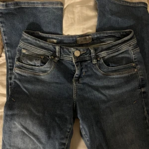 Blå jeans från LTB med raka ben - Snygga blå jeans från LTB med klassisk femficksdesign. But cut Jeansen har en mellanblå tvätt med lätt slitning och detaljerade sömmar på bakfickorna. Perfekta för en avslappnad och trendig look. 