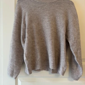  stickad tröja  - Rosa/beige stickad tröja från 157 i storlek XS. Tröjan har en avslappnad passform, ribbade muddar och rund halsringning. 