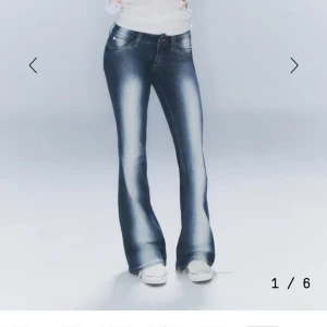 Blå bootcut jeans med slitningar - Snygga blå bootcut jeans med markerade slitningar framtill och klassisk femficksdesign. Jeansen har låg midja och är tillverkade i ett stretchigt denimtyg som sitter skönt. Perfekta för en avslappnad och trendig look. Använt 2 gånger 