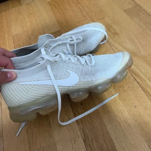 Nike  Vapormax vita skor  -  Nike Air Vapormax sneakers skor. Skorna har klassisk snörning, stor vit swoosh på sidan och tydlig Vapormax-logga bak. Lätta och luftiga med modern design, perfekt för dig som gillar Nike skor. Storleken är 44 men passar 43.  