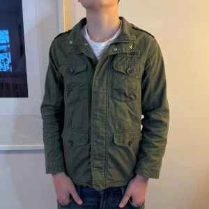 Field jacka - Sjukt fet field jacka i färgen olivgrön. Jackan är i storlek 140 men modellen på bilden är 166cm och den är lite liten. Jag skulle säga att den passar någon runt 155-160. Jackan är från hm men säljs inte längre så den går inte att få tag på. Nypris: vet inte, mitt pris: 650kr! Hör av dig vid minsta fråga eller fundering 🤔 