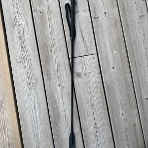 Svart ridspö med handtag - Säljer ett svart ridspö med greppvänligt handtag och ögla för enkel hantering. Spöet är smalt och flexibelt, perfekt för ridning. Tillverkat i syntetmaterial och har en stilren, enkel design utan mönster.