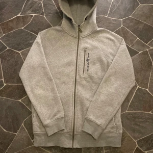 Sail Racing Zip - En mycket fin zip ifrån Sail Racing, tröjan har den klassiska gamla modellen med inga defekter som syns. Som du kan se på bild 4 så saknas det en grej för zipper vid bröstet. Zipper för själva tröjan kan trassla ibland men den fungerar som den ska. Som sagt inga synliga defekter bara något man kan tänka på.  Pris kan diskuteras!