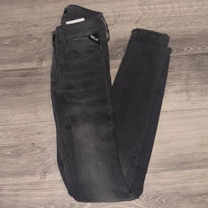 Replay svarta skinny jeans New Luz - Svarta skinny jeans från Replay, modell New Luz. Jeansen har klassisk femficksdesign, knapp och dragkedja framtill samt Replay-logga vid fickan. Snygg tvättad look och stretchigt material för en bekväm passform.