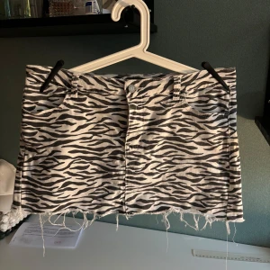 Zebramönstrad jeanskjol med fransig kant - Snygg kort jeanskjol med svartvitt zebramönster och rå, fransig kant nertill. Har används men ingen tecken på slitning!! Storlek 38💗