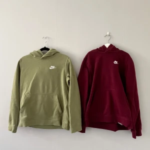 Nike hoodies i olivgrön och vinröd - Två stilrena hoodies från Nike, en i olivgrönt och en i vinrött. Båda har klassisk huva, magficka och Nike-logga broderad i vitt på bröstet. Perfekt för dig som gillar enkel och sportig stil. Materialet är mjuk bomullsmix och passformen är normal med långa ärmar. Samma storlek på båda, (147/158) .Använda typ 2-3 gånger, 160kr för båda eller 90kr styck - Hör av er vid frågor eller funderingar, Mvh Sigge 🥂