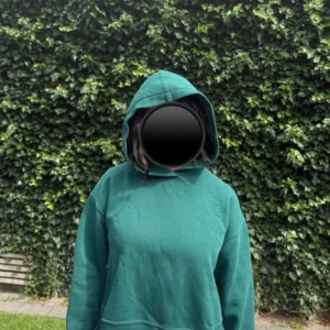 Grön hoodie från Zara i bomull - Mysig grön hoodie från Zara i storlek L. Tröjan har en klassisk huva och är tillverkad i mjuk bomull och polyester. Perfekt för dig som gillar en enkel och avslappnad stil. Långärmad modell med normal passform.