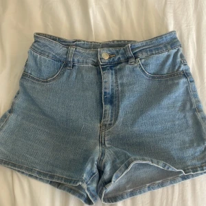  ljusblå jeansshorts från H&M i storlek 34 - Ljusblåa jeans shorts från H&M i storlek 34. Shortsen är klassade som high waist men skulle själv kalla med mid waist pga att shortsen är exakt på naveln. Väldigt töjbara o sköna shorts samt väldigt mjukt jeans tyg. Shortsen har en slits på sidan och är dom perfekta shortsen att vika ner om man skulle vilja ha dom lägre i midjan🤍🤍🤍🤍.