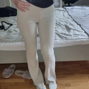 Ribbade beige byxor med bootcut - Säljer ett par ribbade beige byxor med bootcut och hög midja. Byxorna är stretchiga och sitter tajt upptill men släpper ut vid benen. Perfekta för en chill och trendig look. Superbekväma och snygga till sneakers eller sandaler.